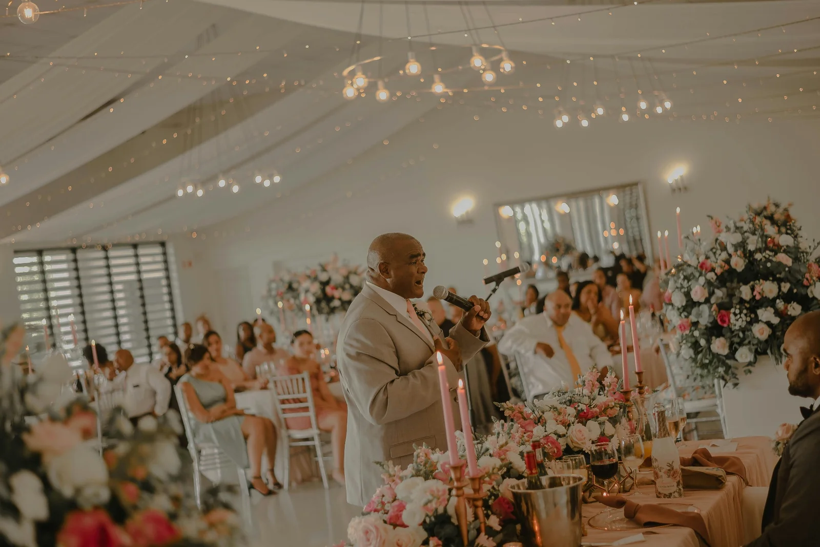 Father of the bride giving a speech in a candlelit room