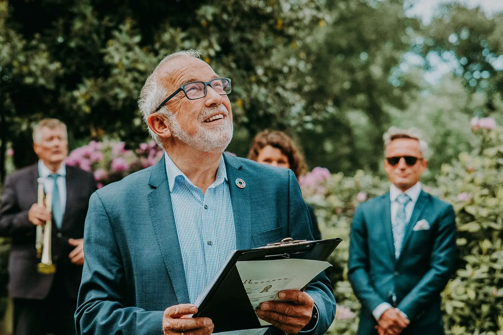 Wedding celebrant smiling while delivering a speech in a garden